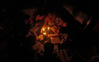 Una profesora da clases a la luz de las velas en Calcuta.