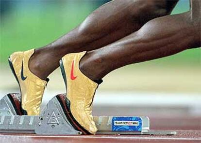 Las zapatillas del atleta Michael Johnson, enfocadas en la posición de salida, durante la carrera semifinal clasificatoria de los 400 metros de los Juegos Olímpicos de Sydney, en 2000.