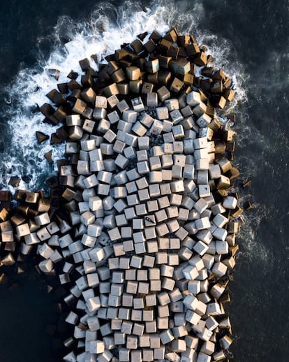 Márton Mogyorósy, un fotógrafo de 18 años especializado en arquitectura e imágenes aéreas, en medio de uno de los espigones de Barcelona.