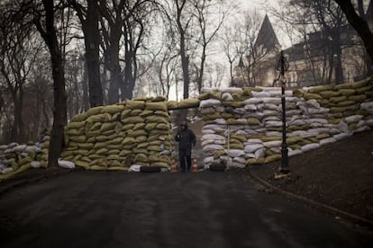 Un opositor al gobierno ucranio hace guardia en una barricada en Kiev.