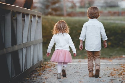 Dos niños caminan por un puente.
