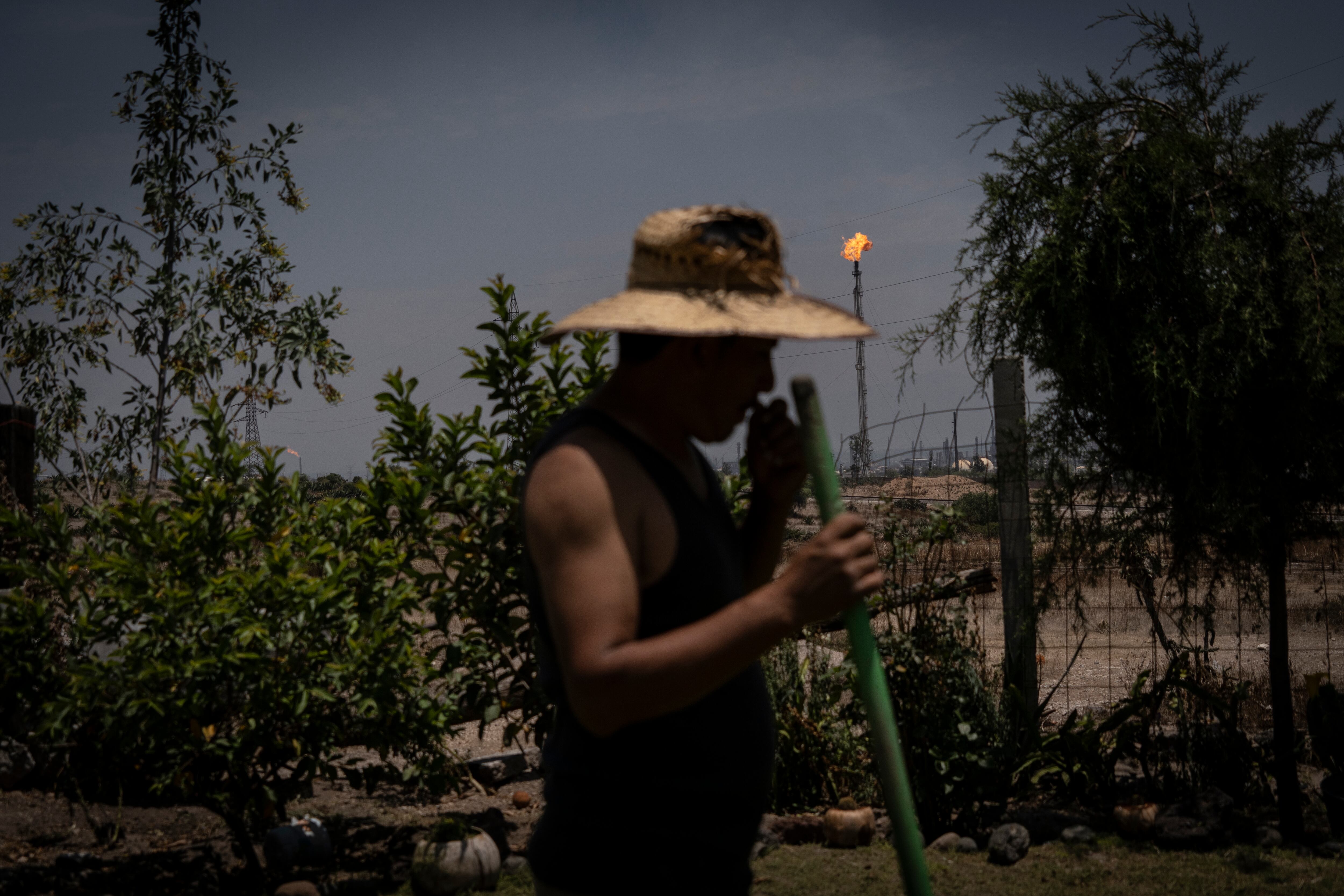 Luis León Martínez poda su jardín aledaño a la refinería. 