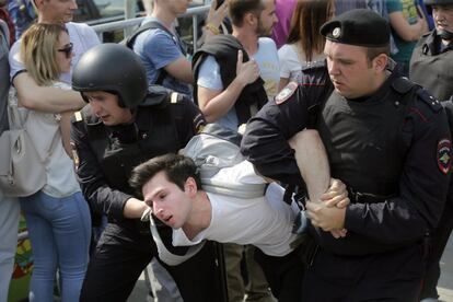 Un joven es detenido durante una protesta ilegal contra Vladimir Putin por el centro de Moscú (Rusia).