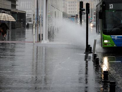 Un autobús urbano salpica al pasar por un charco en San Sebastián.