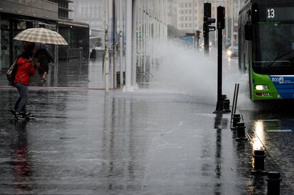 Un autobús urbano salpica al pasar por un charco en San Sebastián.