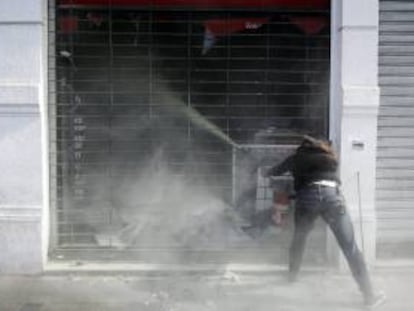 En la imagen, un encapuchado vacía un extintor en un local el 1 de mayo de 2012, durante los disturbios que se produjeron tras la marcha convocada por la Central Unitaria de Trabajadores por el centro de Santiago de Chile para celebrar el Día Internacional del Trabajo. EFE/Archivo