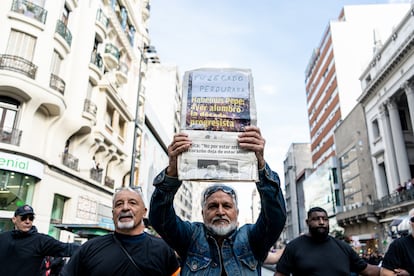 Un simpatizante de José Mujica muestra las portadas  de prensa al paso de la carroza fúnebre.