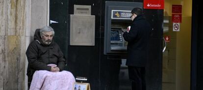 Un hombre pide a la puerta de una sucursal bancaria en Madrid.