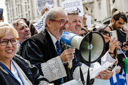 El decano emérito del colegio de abogados de Málaga, José Francisco Lara Peláez, sujeta un megáfono durante una protesta para reclamar mejoras laborales, frente al Congreso de los Diputados.