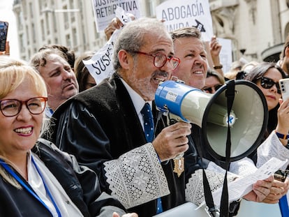 El decano emérito del colegio de abogados de Málaga, José Francisco Lara Peláez, sujeta un megáfono durante una protesta para reclamar mejoras laborales, frente al Congreso de los Diputados.