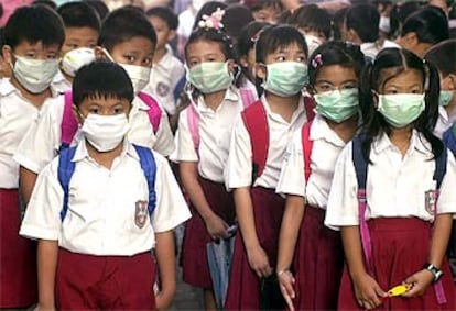 Colegiales indonesios en Yakarta con mascarillas para protegerse de la neumonía.