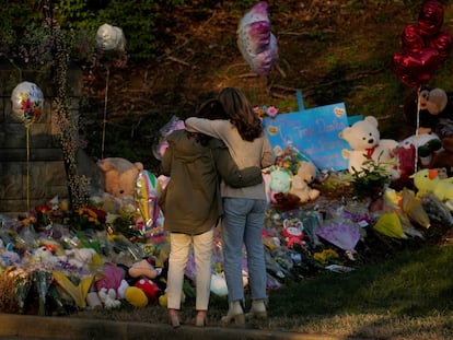 Community members embrace while visiting a memorial at the school entrance after a deadly shooting at the Covenant School in Nashville, Tennessee, on March 29, 2023.