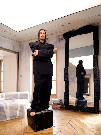 Nuriev posa en el salón vestido de Balenciaga, de espaldas a un espejo hecho con teclados de ordenador.