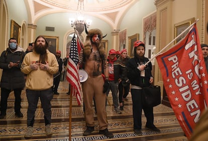 Algunos de los asaltantes al Capitolio de Estados Unidos portando una bandera en favor de TRump, el 6 de enero de 2021.