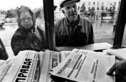 Dos ciudadanos rusos se acercan a un quiosco para comprar un periódico.