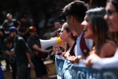 Una joven grita arengas a través de un megáfono durante una marcha en pro del medio ambiente y para generar consciencia del cambio climático este viernes, en Santiago (Chile).