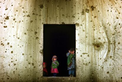 Un grupo de niños refugiados afganos hacen muecas desde una de las ventanas de la antigua embajada de la URSS en Kabul, en una imagen tomada el 27 de noviembre de 2001.