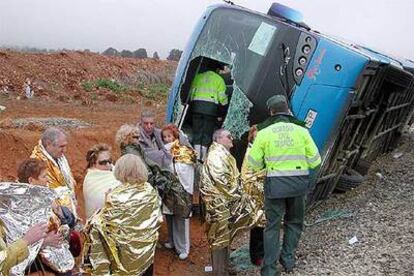 Guardias civiles inspeccionan el autobs en el que viajaban 50 jubilados tras volcar en la Puebla de Valverde (Teruel).