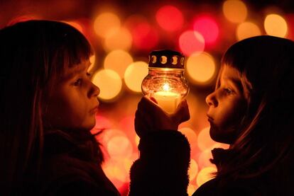 Amalia y Lesana, gemelas de 5 años, juegan con una vela en un cementerio de Ivanka pri Dunaji cerca de Bratislava.