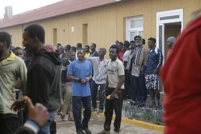 Los inmigrantes se agolpan ante la entrada del centro de acogida de Melilla, a la espera de ser atendidos por la policía.