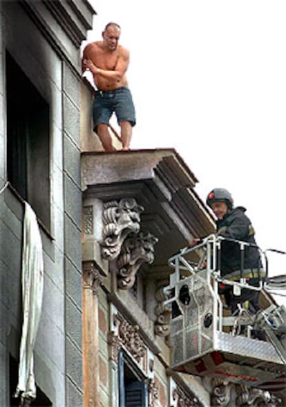 Los bomberos rescatan a uno de los inquilinos del piso siniestrado.