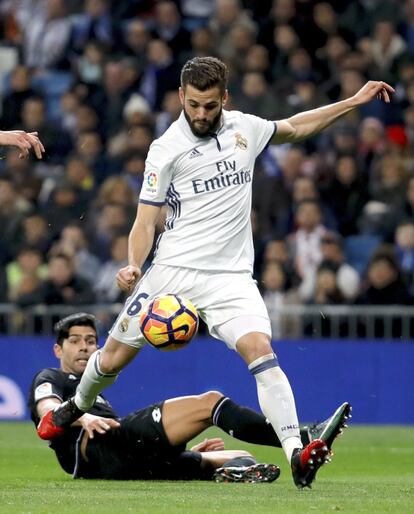 El defensa del Real Madrid Nacho Fernández disputa un balón con Juanfran, defensa del Deportivo.