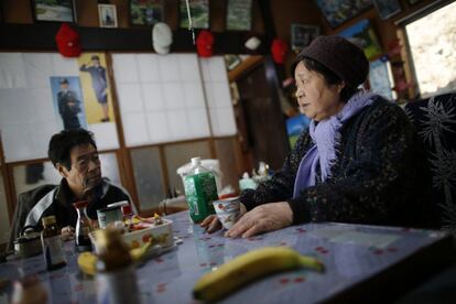 Toshio (izda) y Kimiko Koyama, sentados a la mesa de la casa que dejaron hace tres años, tras el desastre nuclear provocado por el terremoto y el tsunami que siguió. La zona de Miyakoji, donde se encuentra esta zona de exclusión, se sitúa alrededor de la ciudad del mismo nombre, al noreste del país, más alejada de la costa que la central de Fukushima.