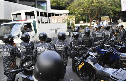 Oficiais da Polícia Nacional permanecem do lado de fora do posto de comando da Guarda Nacional em Cotiza, no norte de Caracas, após um breve levante militar.