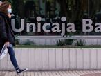 Una mujer pasa ante la sede de Unicaja en Málaga. 