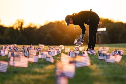 Uma mulher coloca bandeira em homenagem às vítimas no Memorial Project em Washington, em 21 de setembro de 2020.