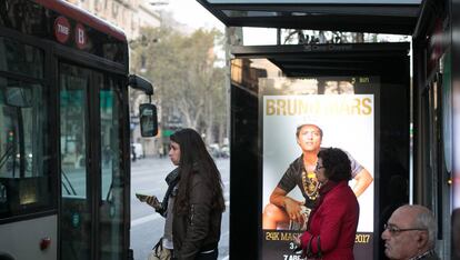 Ciudadanos esperan en una marquesina la llegada de su autobús.