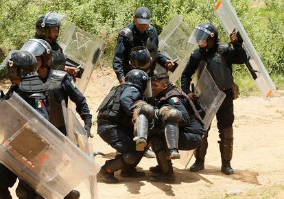 Policías antidisturbios ayudan a un compañero herido durante los enfrentamientos con el sindicatos de maestros durante una protesta contra la reforma educativa en la ciudad de Nochixtlan (México).