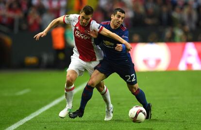 El defensa del Ajax Joel Veltman y el centrocampista del Manchester Henrikh Mkhitaryan luchan por controlar el balón.