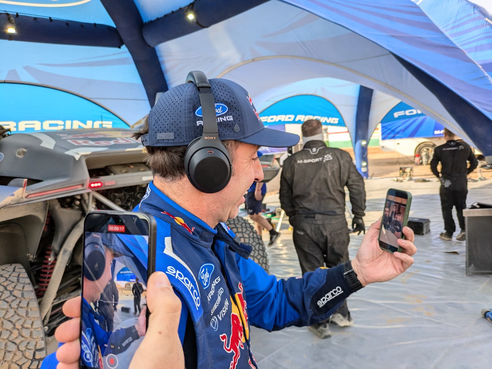Nani Roma escucha a su hijo Marc tras completar la etapa 7 del Dakar.