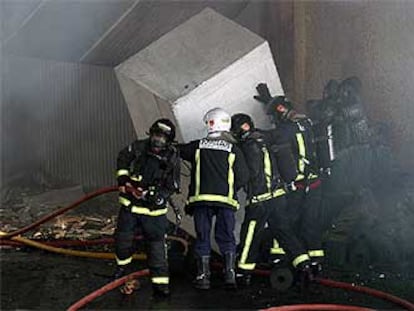 Los bomberos, ayer, luchaban contra el fuego en el interior de la industria incendiada en el polígono Pla de la Vallonga.
