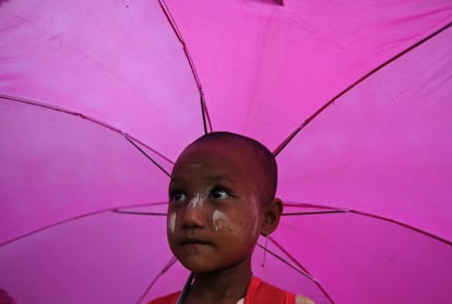 Retrato de un escolar de Myanmar cubierto con un paraguas. 4 de junio de 2014.