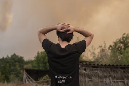 El humo invade la localidad de Bustelo de Lor. Un vecino se echa las manos a la cabeza al observar la acción devastadora del incendio