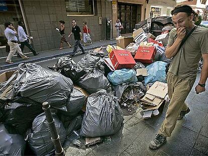 Un hombre se tapaba la nariz, ayer, al pasar junto a la basura acumulada en las calles del centro de Almería.