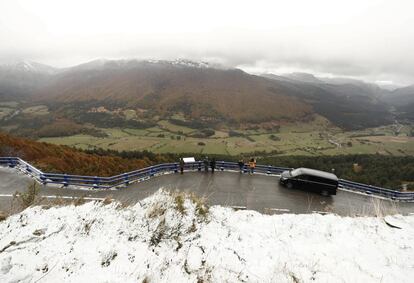 Un grupo de personas observan desde un mirador el valle de Belagoa (Navarra) cuyos bosques presentan los colores típicos del otoño y donde la nieve caída esta madrugada permanece en las cotas mas altas del Pirineo navarro, el 28 de octubre.