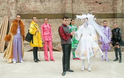 El diseñador Alejandro Gómez Palomo posa con algunos de sus modelos en el 'backstage' de su desfile.