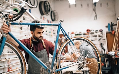 Un pequeño empresario trabaja en el taller de su tienda de bicicletas.