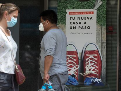 Dos personas pasan ante un anuncio hipotecario en Madrid, en una imagen de archivo.