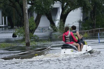 Moradores usam moto aquática para rebocar uma canoa em Bay Saint Louis, Mississippi. O nível da água subiu até dois metros em algumas zonas do Estado de Nova Orleans.