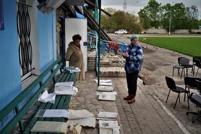 Svetlana, de 55 años (a la derecha), y Veronika, de 63, ponen a secar documentos rescatados del Museo de Historia de Kupiansk.