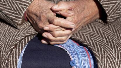 Una anciana entrelaza las manos en Olmeda de la Cuesta (Cuenca). 