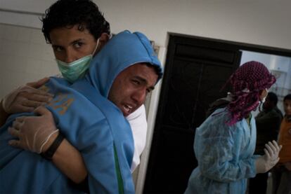 Un joven recibe consuelo de un médico tras reconocer el cadáver de su hermano en el hospital Jalaa, en Bengasi.