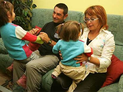 Paula, en las rodillas de su madre, con su padre y su hermana en su casa de Utiel.