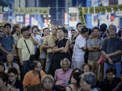 Un grupo de personas escucha un discurso improvisado por organizadores del movimiento prodemocracia en Hong Kong, este lunes.