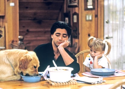 John Stamos como Jesse, junto a una de las hermanas Olsen, en su papel de Michelle, en la serie 'Padres forzosos'.