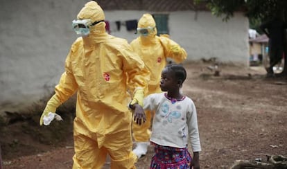 Nowa Paye, sospechosa de tener ébola, es llevada por un sanitario a una ambulancia el pasado 30 de septiembre en un poblado cerca de Monrovia (Liberia).